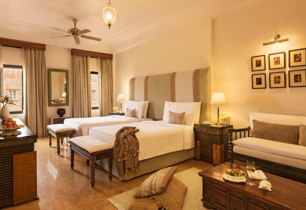 Spacious premium suite with wooden furniture and warm interiors at Suryagarh Jaisalmer destination wedding resort