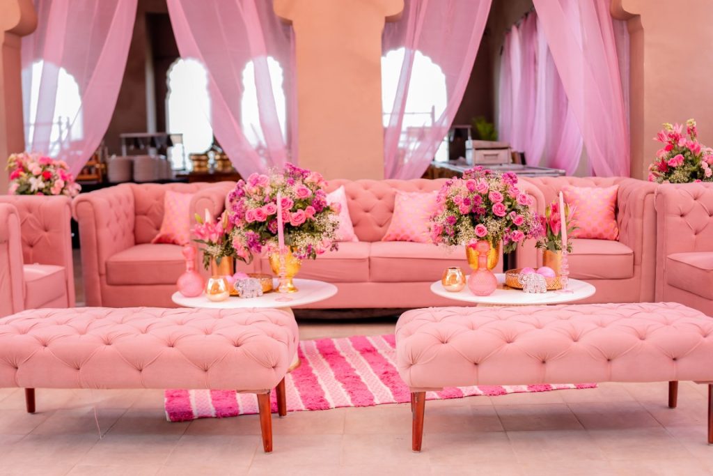 All pink tufted sofa lounge with rose flower arrangements at Haldi ceremony Fairmont Jaipur