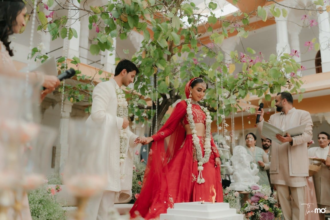 Bride in pink lehenga and groom in white sherwani celebrating after wedding ceremony at a luxury destination wedding in Rajasthan — Desert Pearl Weddings Udaipur