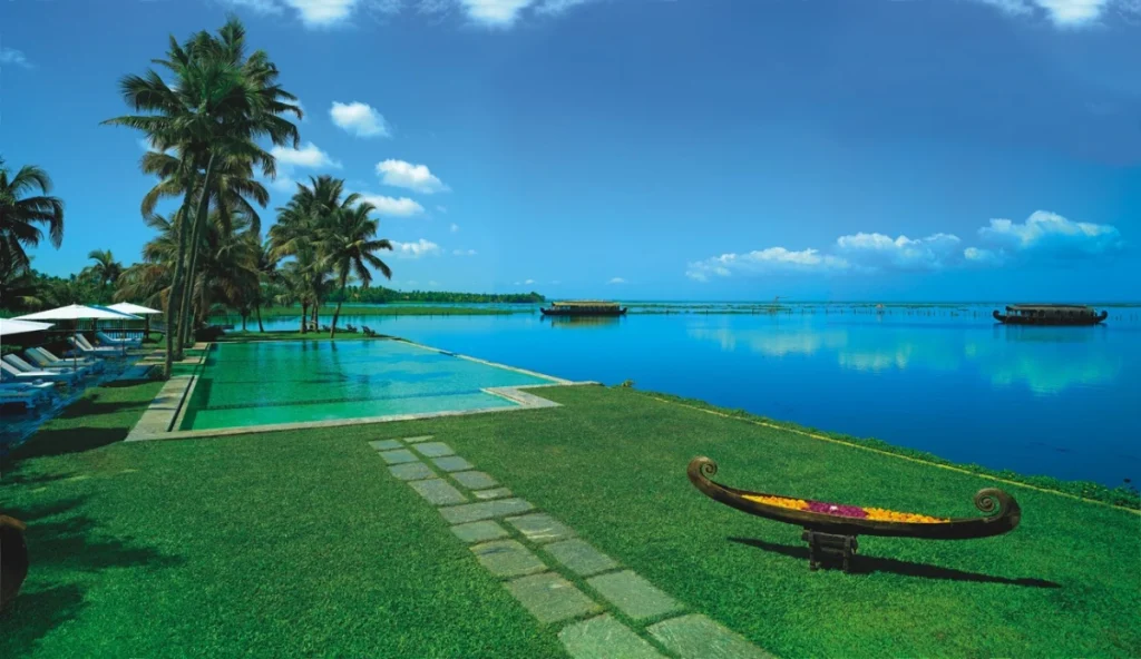 Infinity pool overlooking Vembanad Lake with houseboats at Kumarakom Lake Resort