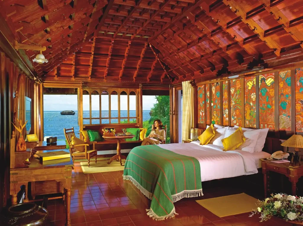 Heritage suite bedroom with Vembanad Lake view and traditional mural at Kumarakom Lake Resort