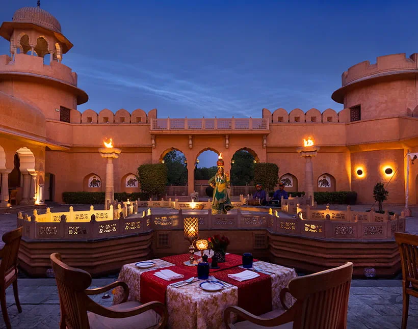 Fort courtyard dining with dancer performance at dusk at The Oberoi Rajvilas, Jaipur