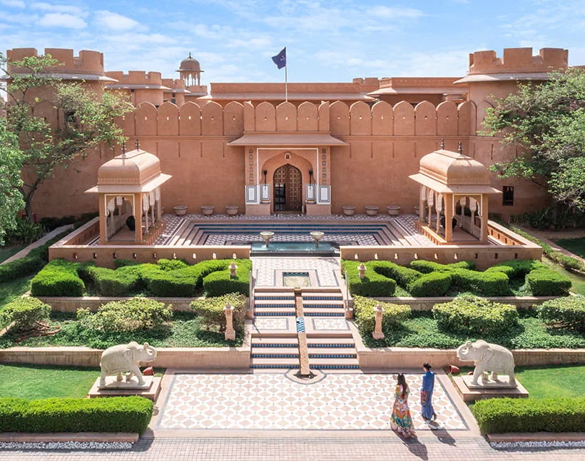 Rajasthani fort-style facade and formal garden aerial view at The Oberoi Rajvilas, Jaipur