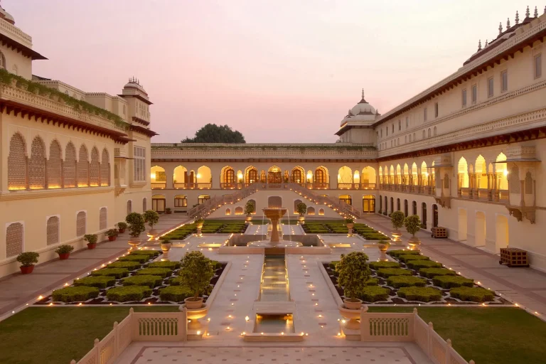 Mughal garden courtyard with fountain at dusk at Rambagh Palace, Jaipur