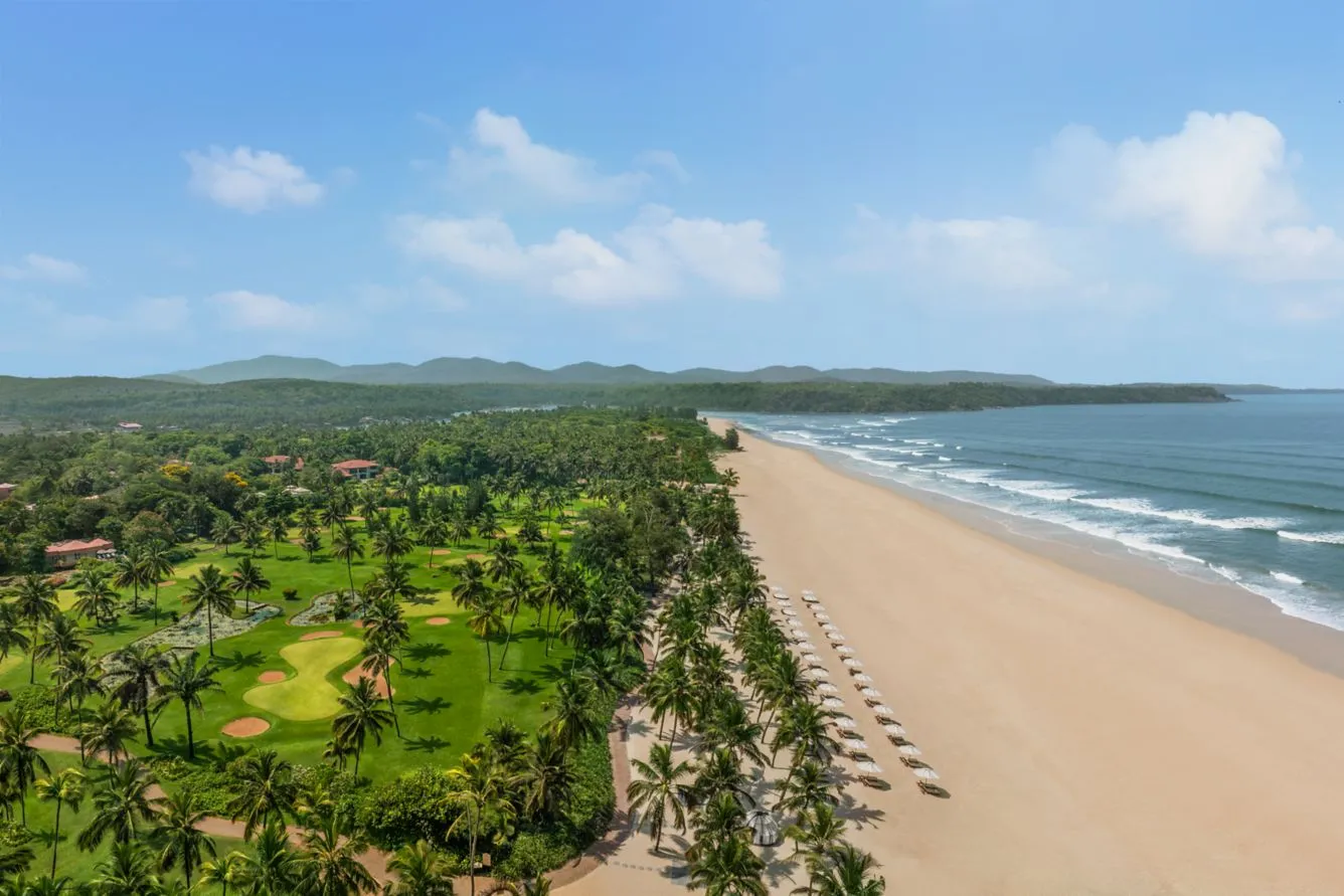 Aerial view of the freeform pool, golf course, and beach at St. Regis Goa