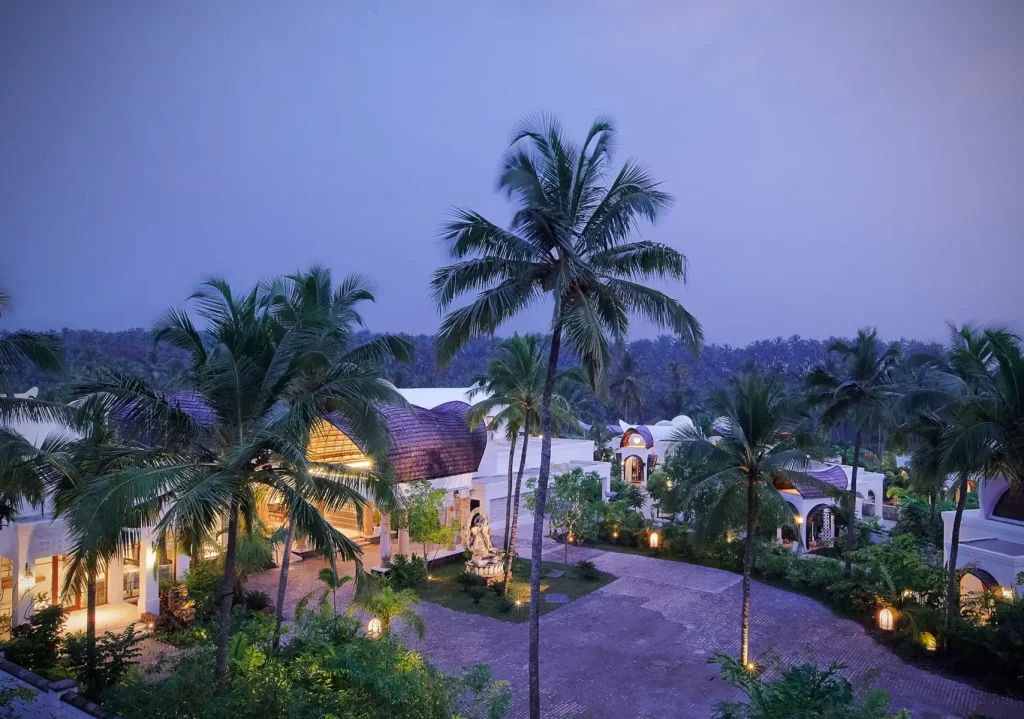 Twilight aerial of Taj Bekal's domed pavilions and palm groves in Kerala