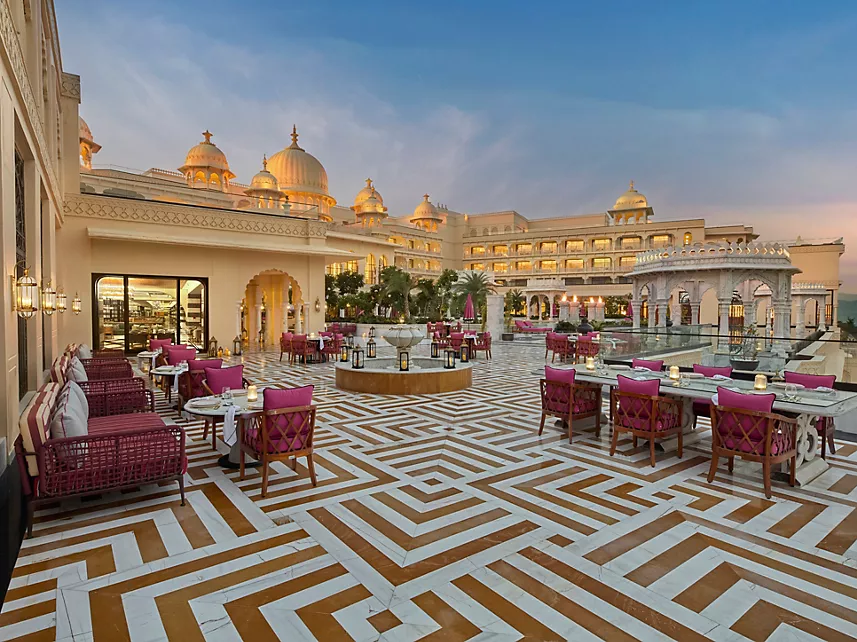 Outdoor terrace restaurant with geometric marble floor and palace facade at Fairmont Udaipur Palace