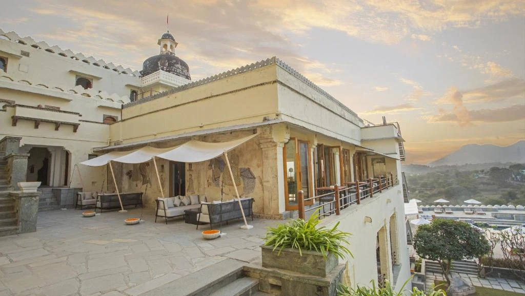 Outdoor terrace dining with white canvas canopy and domed cupola at sunset at RAAS Devigarh Udaipur