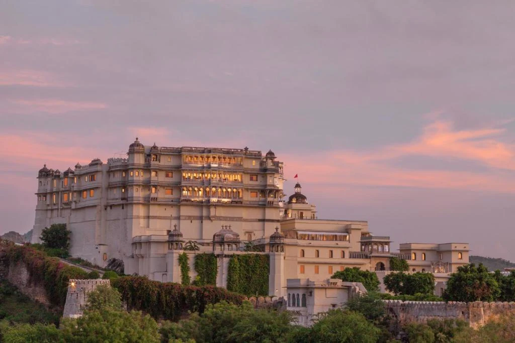 18th-century RAAS Devigarh palace illuminated at pink sunset on Aravalli hilltop Udaipur