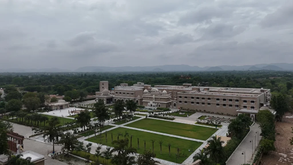 Aerial view of Taj Lalit Bagh Udaipur geometric garden lawns and palace complex with Aravalli hills backdrop