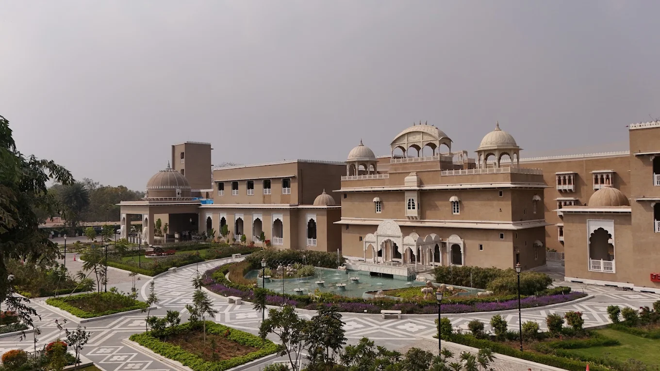 Palace wing exterior with circular water feature garden and geometric stone pathway at Taj Lalit Bagh Udaipur