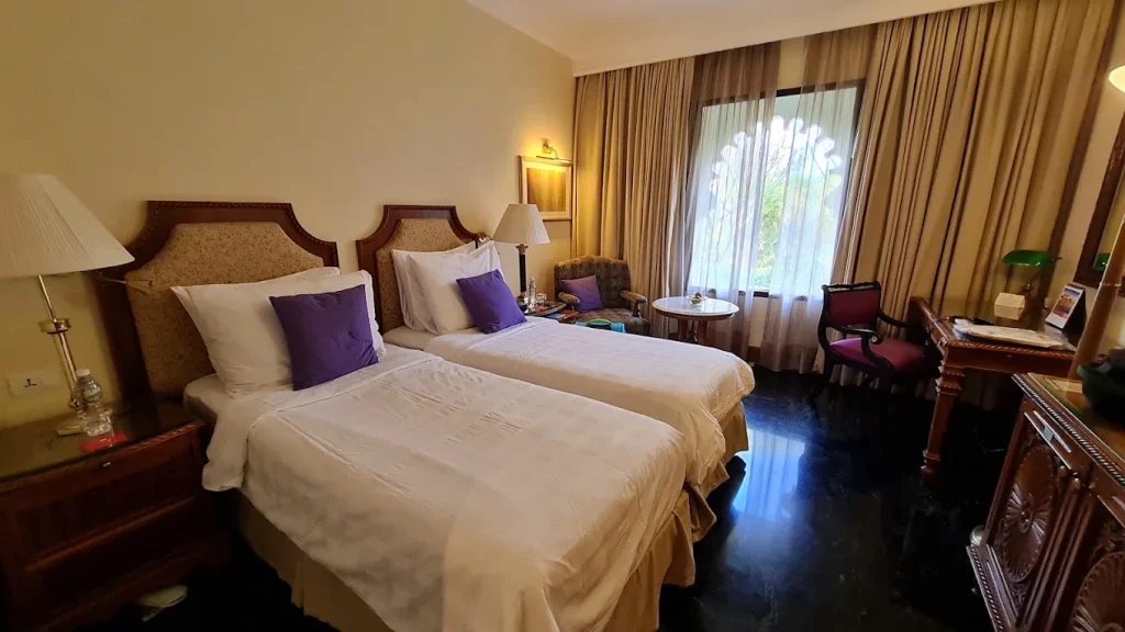 Twin guest room with Rajasthani-inspired furnishings and garden view at Trident Udaipur