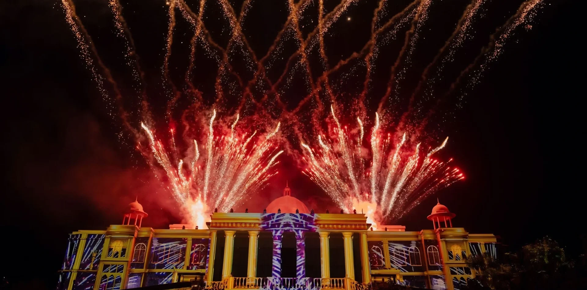 Fireworks and projection mapping lighting up a palace facade at a luxury wedding by Desert Pearl Weddings