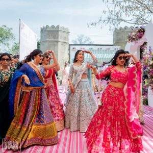 Bride in silver lehenga dancing with friends during Mehendi entry at Fairmont Jaipur