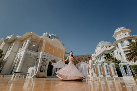 Bride twirling in a pink lehenga at The Leela Palace Jaipur, a beautiful destination wedding portrait captured by Desert Pearl Weddings in Rajasthan