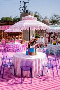 Colorful outdoor Mehendi seating with pink striped umbrellas and acrylic chairs at Fairmont Jaipur