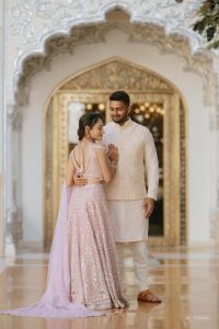 Couple sharing a portrait inside a carved palace archway during their Haldi ceremony at The Leela Palace Jaipur, captured by Desert Pearl Weddings