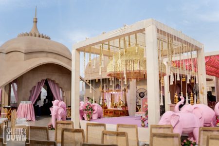 Outdoor Haldi mandap with pink elephant statues and gold hanging decor at Fairmont Jaipur wedding