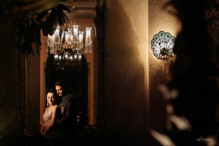 Romantic night couple portrait under a crystal chandelier at The Leela Palace Jaipur, captured at a luxury destination wedding by Desert Pearl Weddings