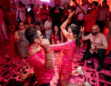 Couple dancing with metallic mirror costume performers at youngsters party Fairmont Jaipur wedding