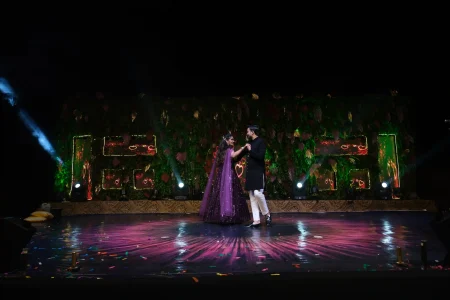 Couple walking hand in hand through guest ribbon wand send-off aisle after ring ceremony at outdoor rooftop engagement celebration destination wedding in Rajasthan by Desert Pearl Weddings